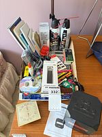 Overall view of box with office supplies, clock radio and desk lamp