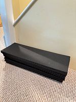 Stack of eleven black rubber stair treads