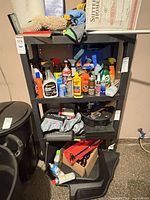 Front view of black plastic shelving unit with contents (not included) showing four shelves