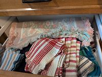 Drawer with woven table mat and multiple striped kitchen towels