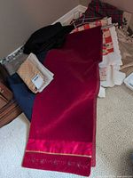 Group of assorted linens with red runner on top