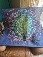 Full view of printed burlap wall hanging showing concentric circle design and rod