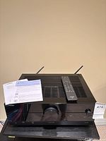 Front view of Yamaha RX-A2A receiver with remote, documentation and antennas visible