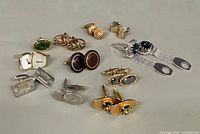 All 11 pairs of cufflinks arranged on surface