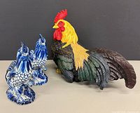 Group shot of resin rooster with two porcelain roosters