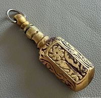 Full view of brass Surmadani showing engraved floral panel and stopper attached