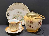 Group shot showing plate, teacup with saucer, and cookie jar