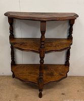 Front view of three-tier half-moon wooden table