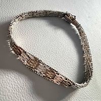 Full view of sterling silver woven link bracelet laid flat