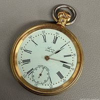 Front view of gold-tone Aurore pocket watch showing dial and case