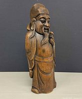 Full front view of carved wooden Asian scholar statue