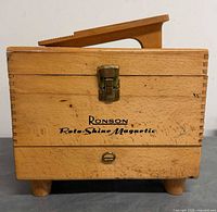 Front of wooden box showing logo, latch, feet