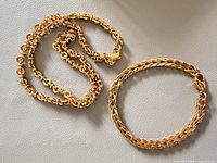 Necklace and bracelet laid flat to show links and clasps