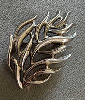 Front view of silver-tone leaf brooch showing openwork design