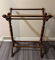 Front view of wooden quilt rack showing overall structure and finish