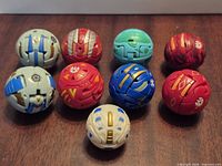 Nine Bakugan spheres closed; assorted colors visible