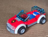 Front left view of assembled LEGO fire chief car showing hood emblem, windshield and wheels