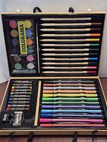 Open kit showing pencils, markers, pastels, watercolors, brush and sharpener