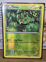 Front of sleeved Snivy reverse holo card