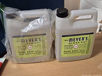 Front view of both hand soap refill bottles, one wrapped, one unwrapped
