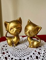 Front view of both brass cat figurines