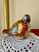 Front angled view of glazed ceramic bird showing multicolour finish