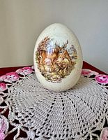 Front view of speckled ceramic egg showing deer family decal