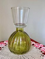 Front view showing olive green ribbed base with clear flared top