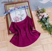Full view of burgundy silk camisole laid flat, showing overall garment