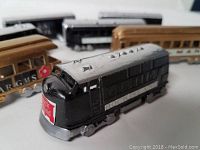 Close-up of a black metal locomotive with 'Rock Island' logo on front, showing paint detail and wheels.