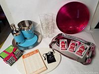 Photo showing stainless steel serving tray, blue leather accent bar set, glass tumblers, pink serving tray, drink tags in original packaging, knockout notepad, wine stopper