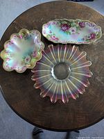 Three serving pieces: two floral porcelain dishes and one iridescent glass plate