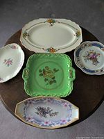 Top view of all five antique porcelain serving dishes arranged on round table