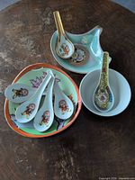 Stacked porcelain bowls and soup spoons showing patterns and shapes