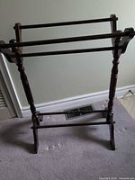Front view of wooden blanket stand showing two rails and turned legs