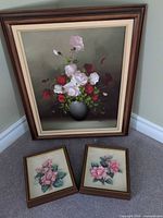 Three framed floral pictures on floor