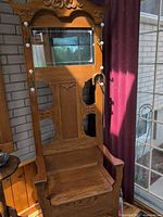 Full view of hall stand showing mirror, hooks, carved details, and bench seat