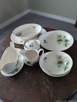 All pinecone pattern china pieces grouped on table