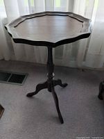 Full view of table showing pedestal base and scalloped top