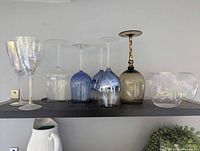 Full group of assorted glasses upside down on shelf
