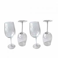 Four identical tall white wine glasses upright and inverted