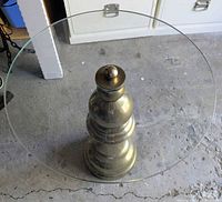 Top view showing round glass top and pawn-shaped brass base