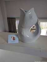 Front view of white GurglePot pitcher with tag