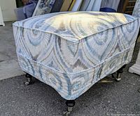 Front angled view showing slipcovered ottoman and casters
