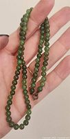Necklace held in hand showing bead size and clasp