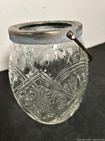 Front view showing cut crystal pattern, silver-plated rim, handle down