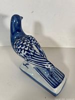 Left side view of blue and white porcelain bird on base