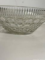 Side view of clear pressed glass bowl showing button and cane pattern and ribbed rim