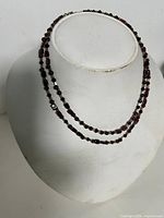 Full view of layered garnet bead necklace on bust