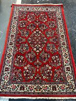 Full view of rug showing overall design, red field, ivory border